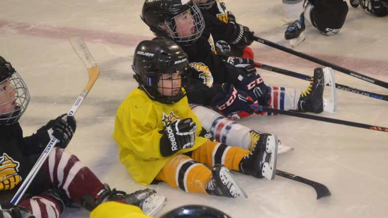 Children in hockey attire on ring