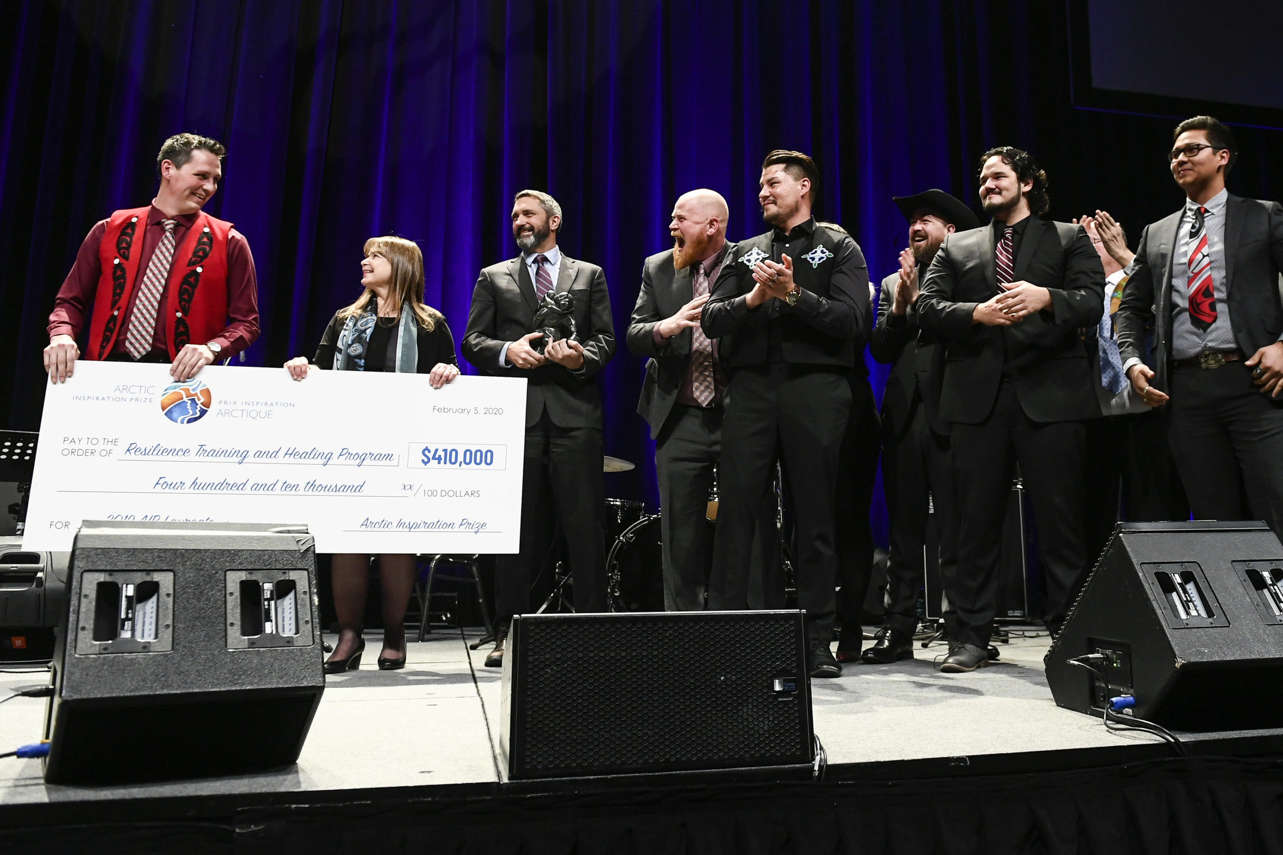 people on stage with big cheque
